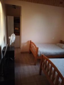 um quarto com 2 camas e uma secretária com uma ventoinha em Hospedaje Atitur em San Pedro de Atacama