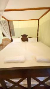 a bed with two white towels on top of it at Villa Dilinga in Galle