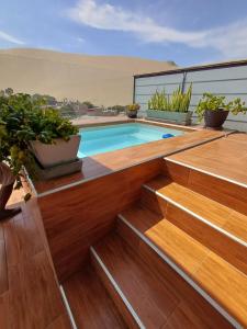 una piscina sul tetto di una casa con scale in legno di Departamento moderno para 6 personas Ica a Ica
