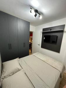 a bedroom with two beds and a flat screen tv at Apartamento cuiaba climatizado in Cuiabá