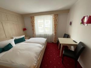 um quarto de hotel com uma cama grande e uma secretária em Hotel JMS Holiday Allgäu em Oberreute
