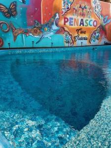 a pool of blue water with a painting on a wall at Hotel Casa Victoria in Puerto Peñasco