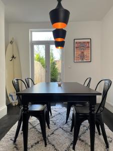 a black dining room table with chairs and a lamp at Restored Victorian Home with Private Garden in Bristol