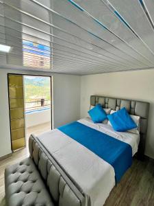 ハルディンにあるFinca Hotel el Recreo de Gloriaのベッドルーム(青い枕の大型ベッド1台付)