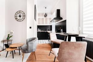 uma cozinha com paredes brancas e uma mesa e cadeiras em Le 107Chinon em Chinon