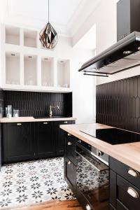 uma cozinha com armários pretos e piso em azulejo preto e branco em Le 107Chinon em Chinon