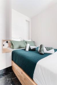 sypialnia z dużym łóżkiem z zieloną i białą pościelą w obiekcie Le 107Chinon w mieście Chinon
