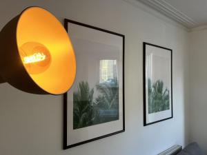 a lamp hanging on a wall with three pictures at Restored Victorian Home with Private Garden in Bristol