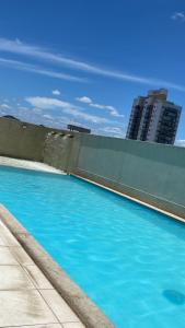 een zwembad met blauw water voor een gebouw bij ITAPARICA BEACH CLUB in Vila Velha
