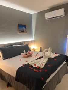 Un dormitorio con una cama con un cisne. en Flat Samba en Cabo Frío
