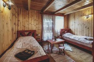 1 dormitorio con 2 camas, mesa y ventana en Csodál-Lak, en Sovata