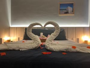 dois cisnes feitos de toalhas numa cama em Flat Samba em Cabo Frio