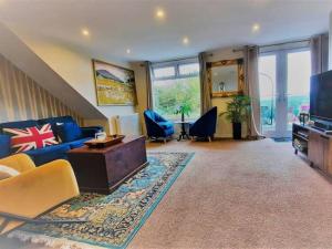 a living room with a blue couch and a tv at Brixham View House in Torquay