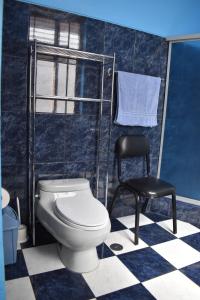 a bathroom with a toilet and a black chair at Casa a 3 cuadras de la plaza de armas Huamanga in Ayacucho