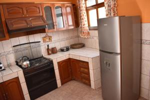 a kitchen with a stainless steel refrigerator and wooden cabinets at Casa a 3 cuadras de la plaza de armas Huamanga in Ayacucho