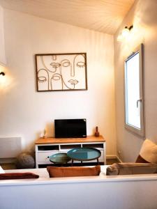 a living room with a couch and a table at A 150m du port, Le Baia, tout à pied in Saint-Martin-de-Ré