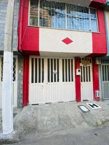 um edifício vermelho e branco com duas portas brancas em Bogotá Kings 302 em Bogotá