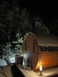 una pequeña casa con una vela delante de ella en Domki trzy jeziora z zewnętrznym SPA - sauna, balia do schładzania i jacuzzi, en Małe Swornigacie
