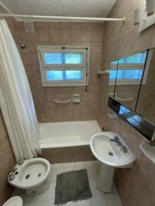 a bathroom with a sink and a tub and a toilet at Hermosa casa zona céntrica Bariloche in San Carlos de Bariloche