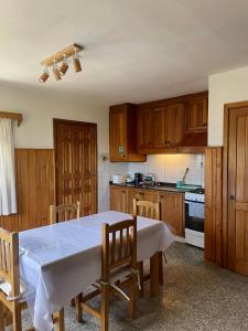 a kitchen with a table and wooden cabinets at Hermosa casa zona céntrica Bariloche in San Carlos de Bariloche