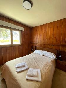 Hermosa casa zona céntrica Bariloche في سان كارلوس دي باريلوتشي: غرفة نوم عليها سرير وفوط
