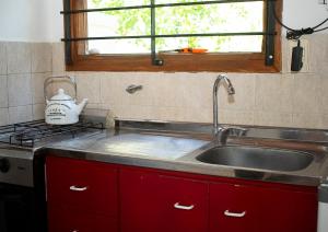 a kitchen with a sink and a stove and a window at Bosque & Mar in Mar del Plata