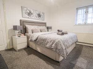 a bedroom with a bed with a teddy bear on it at Swallow Cottage in Herne Bay