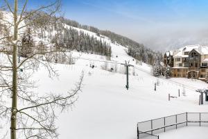a snow covered ski slope with a ski lodge at The Village Ski In Ski Out in Beaver Creek