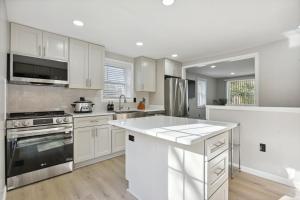 cocina con armarios blancos y fogones en Luxury 3 BR Single Family Home - Half acre lot en Herndon