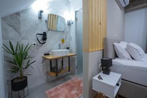 a bathroom with a sink and a toilet in a room at THE ROOMS in Kato Loutraki