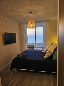 a bedroom with a bed with a view of the ocean at Departamento con espectacular vista al mar Arica, Condominio Ayllu in Arica