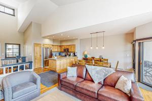 a living room with a couch and a kitchen at The Village Ski In Ski Out in Beaver Creek