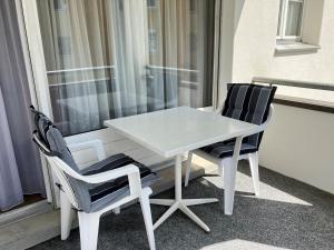 a white table and two chairs in front of a window at Landwasser in Davos