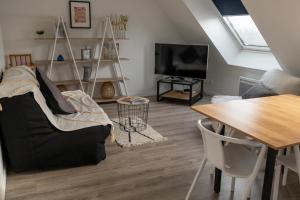 ein Wohnzimmer mit einem Sofa und einem Tisch in der Unterkunft La Roseraie des Princes in Montbéliard