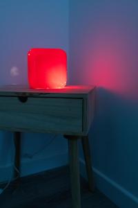 a red lamp sitting on top of a wooden table at La Roseraie des Princes in Montbéliard