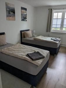 2 camas individuales en una habitación con ventana en Whg 4 Willkommen in unserer gemütlichen Ferienwohnung an der Ostsee!, en Scharbeutz