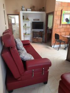 un sofá rojo en la sala de estar con TV en Casa finca El Girasol, en Guayabal de Síquima