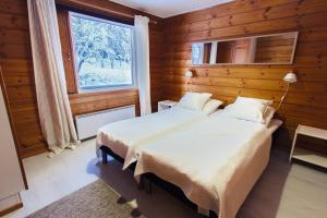 een slaapkamer met 2 bedden en een raam bij Rukan Talvihovit in Ruka