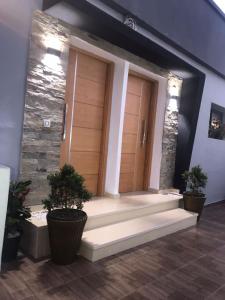 een lobby met twee houten deuren en twee potplanten bij Chez Maria in Kenitra