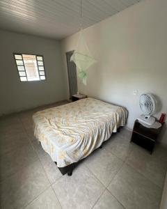 a bedroom with a large bed and a fan at Chácara Recanto da Paz in Caldas Novas