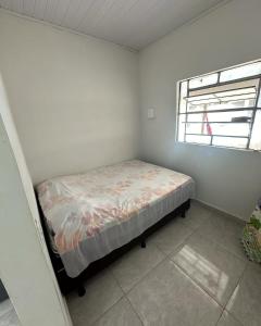 a small bedroom with a bed in a room with a window at Chácara Recanto da Paz in Caldas Novas