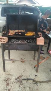 a woman is cooking food on a grill at Casa finca El Girasol in Guayabal de Síquima