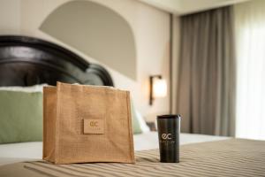 a bag and a coffee cup sitting on a bed at Riu Palace Pacifico - All Inclusive - Adults Only in Nuevo Vallarta