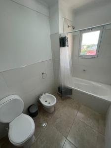 a white bathroom with a toilet and a sink at Pleno Centro in Viedma +7 photos