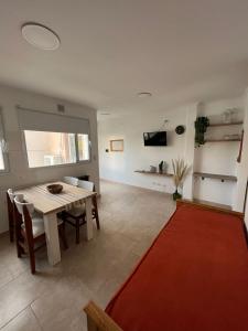 a living room with a table and a red rug at Pleno Centro in Viedma