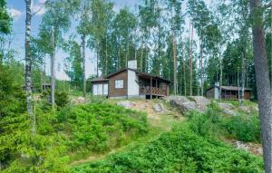 a log cabin in the woods with trees at Lovely Home In Gislaved With Sauna in Askebo