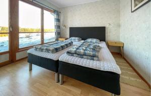 two beds in a room with a large window at Lovely Home In Gislaved With Sauna in Askebo