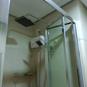 um chuveiro com uma porta de vidro na casa de banho em 1BR Aesthetic Condotel with Balcony - EDSA em Manila