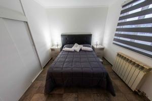 1 dormitorio con 1 cama con 2 almohadas en Gente del Sur - Fagnano en Ushuaia
