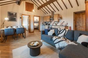 a living room with a blue couch and a kitchen at Glan Morfa Holiday Lodges in Gaerwen